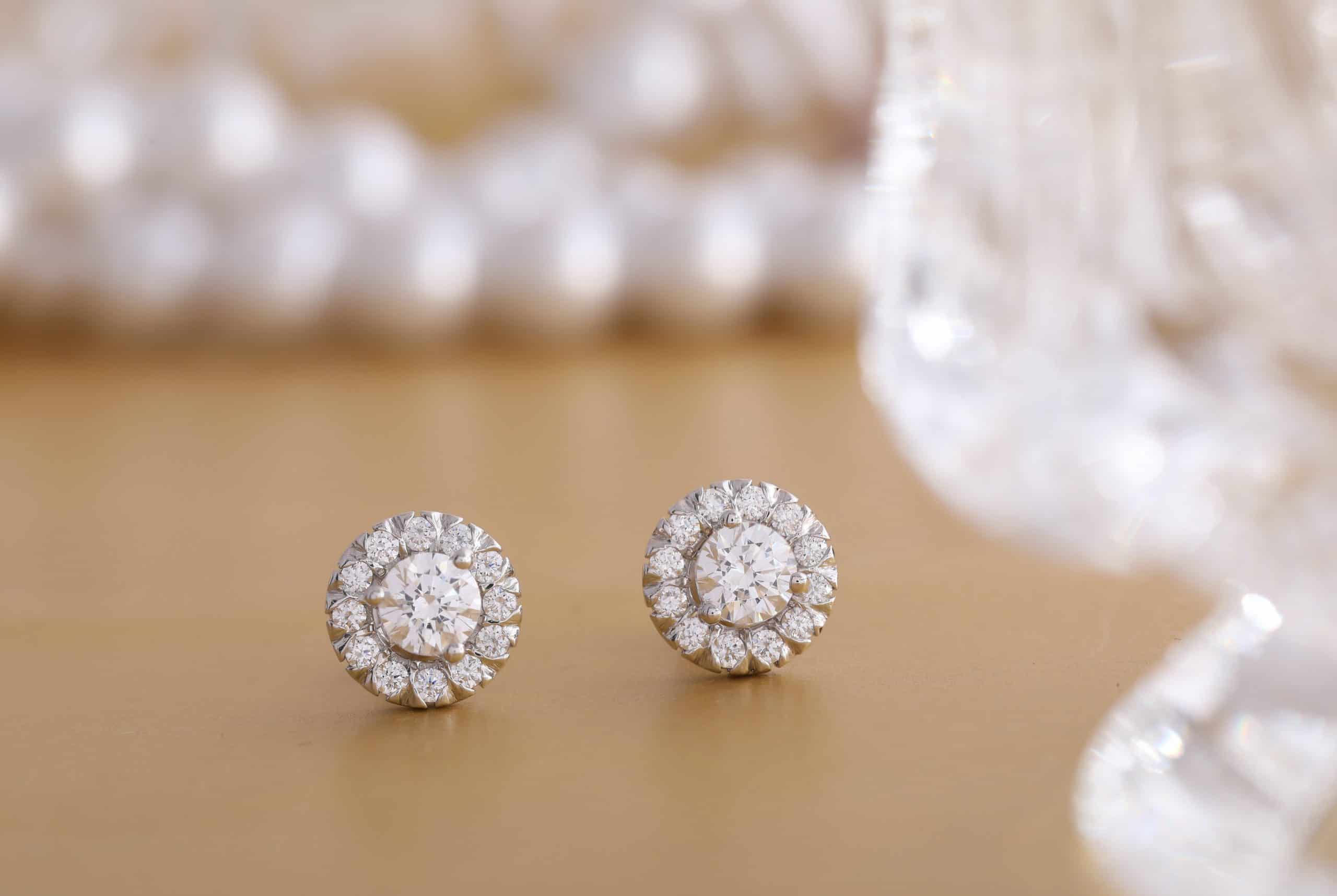 A pair of diamond stud earrings on a table