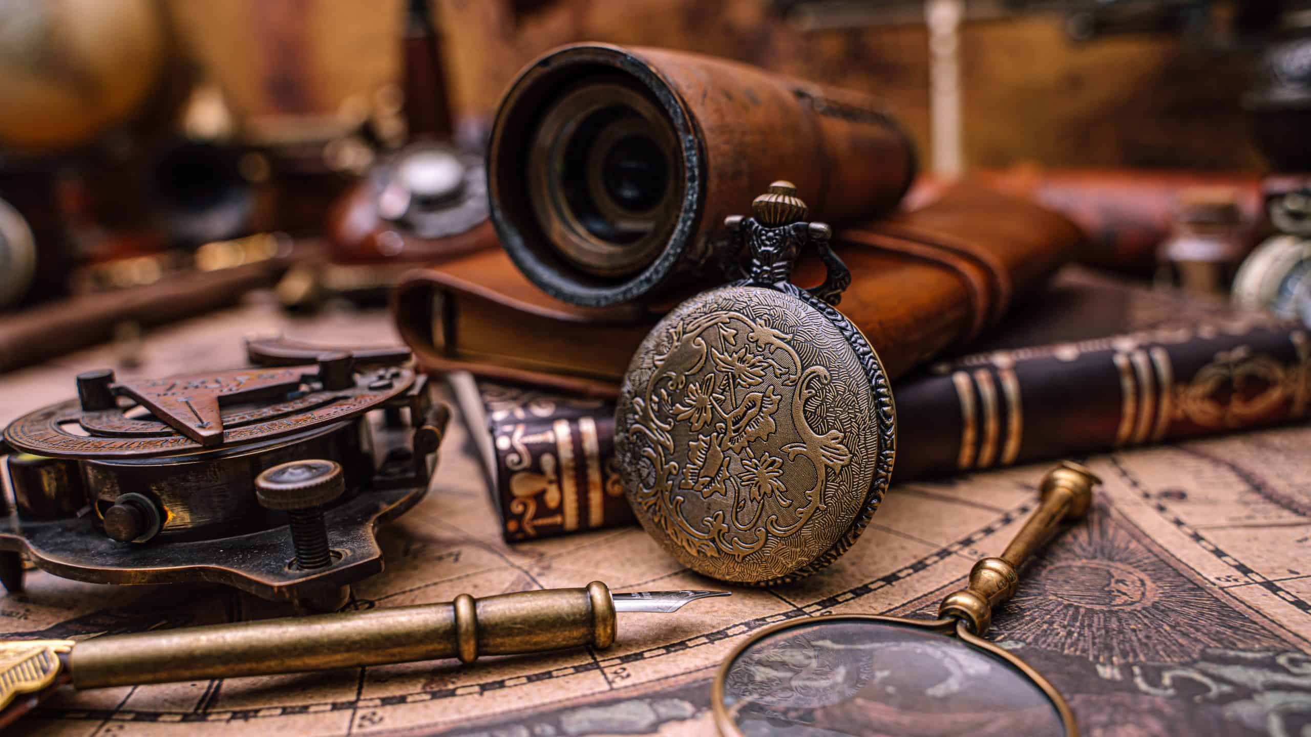 Antique pocket watch, compass, and other items on a map