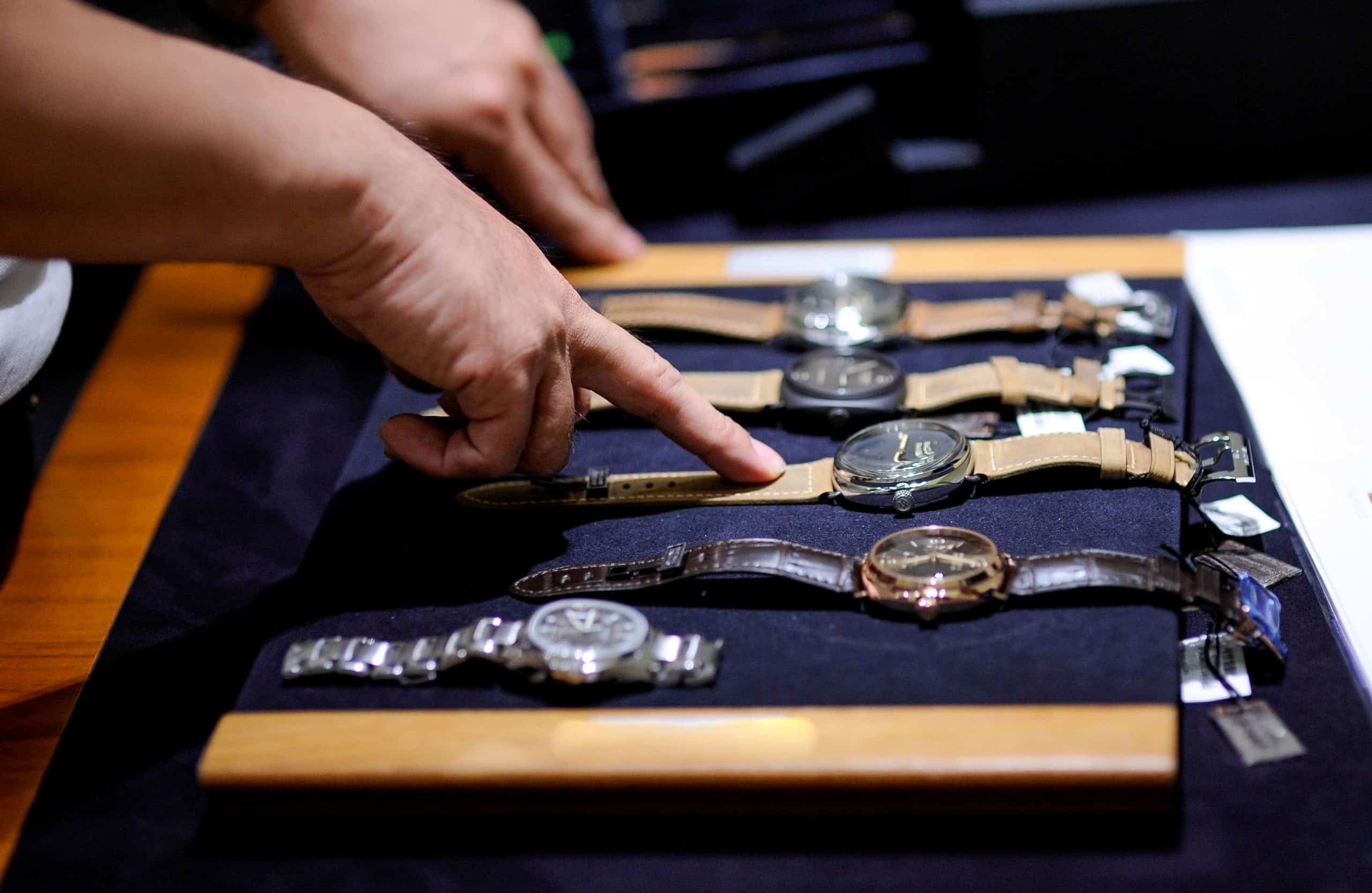 A man pointing at a display of watches