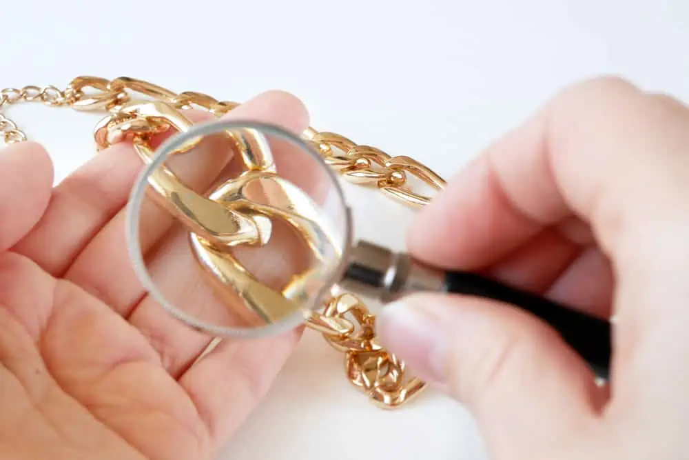 magnifying glass looking at gold necklace